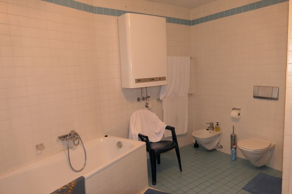 Badezimmer mit Badewanne, Bidet, WC und weiß gefliesten Wänden.