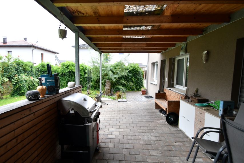Gartenterrasse mit Grill, Holzbank und Gartenmöbeln