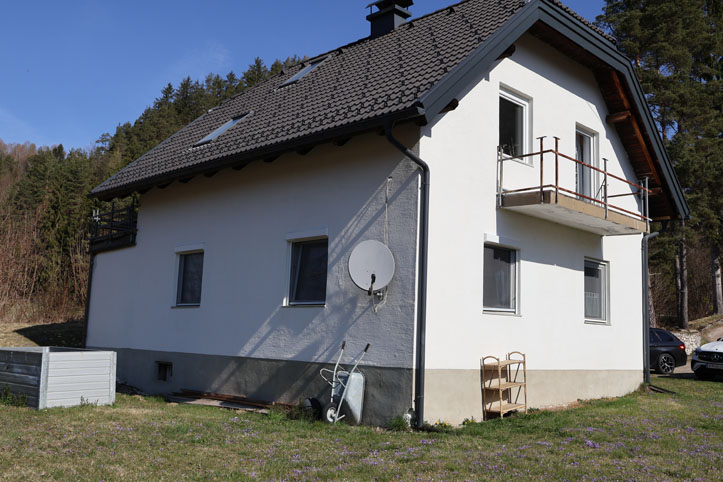 Haus mit Balkon und Satellitenschüssel in ländlicher Umgebung