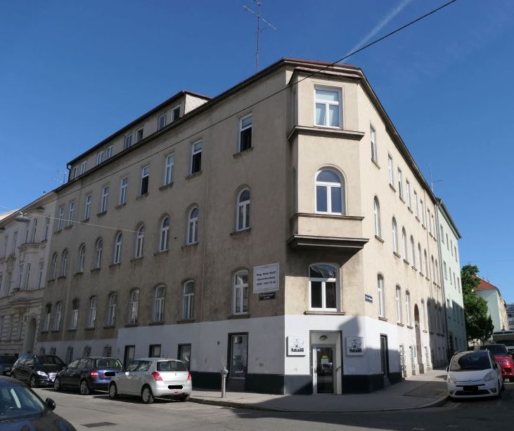 Gebäudeecke in Linz mit mehreren Fenstern und einer Hausfassade im Sommer