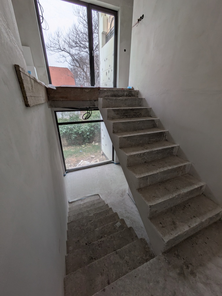 Betontreppen im Rohbau mit Fenstern und Blick ins Freie