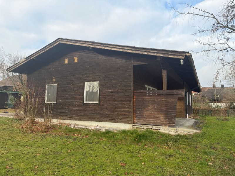 Holzhaus mit Veranda und zwei Fenstern im Garten