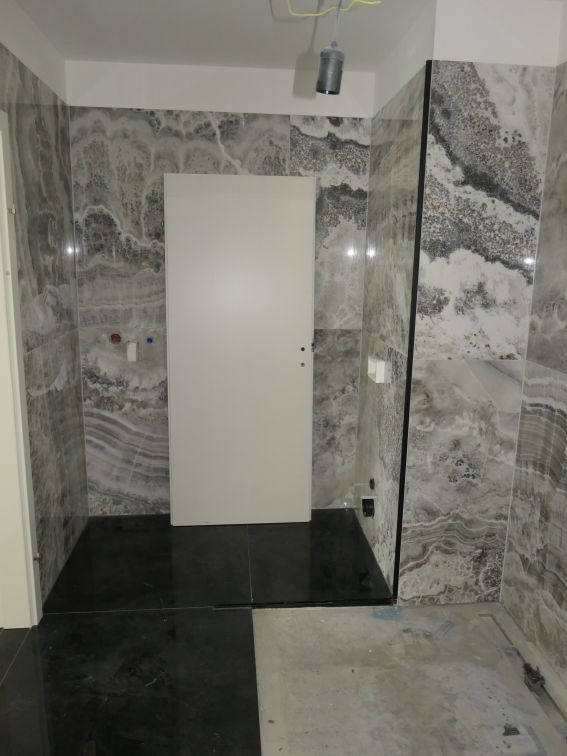 Badezimmer-Umbau mit Marmorfliesen und weißer Tür