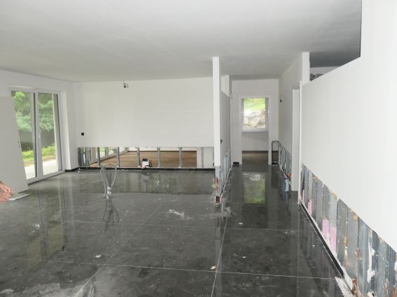 Bauarbeiten in einem modernen Gebäude mit glänzendem Boden und Metallverkleidung an den Wänden