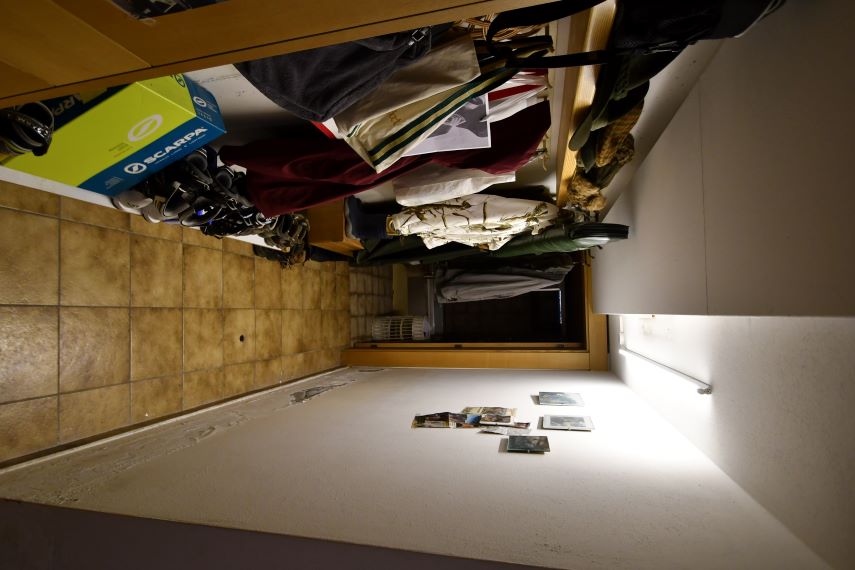 Schuhschachtel, Schuhe und Kleidung in einem Flur mit Fotos an der Wand