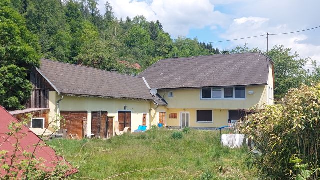 Haus mit Nebengebäude und Garten in ländlicher Umgebung, umgeben von Bäumen