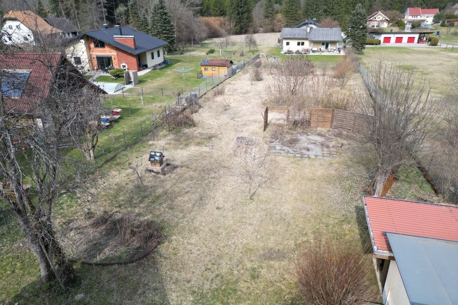 Garten mit Bienenstöcken, Brunnen und Holzhütte in ländlicher Umgebung