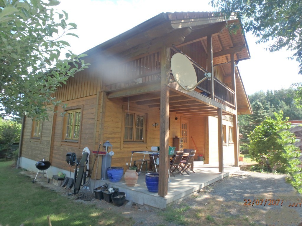 Holzhaus mit Balkon und Gartenmöbeln, Satellitenschüssel, Grill, Gartengeräte